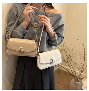 Détail de sacs à bandoulière minimalistes avec d'élégantes boucles dorées en forme d'arche