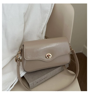 Détail du sac baguette kaki minimaliste montrant le fermoir doré et le rabat lisse