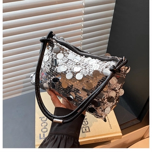 Detailed view of silver sequin shoulder bag with black knotted strap and zipper closure
