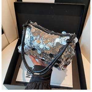Close-up of sparkling silver oversized sequins on a metallic shoulder bag for women