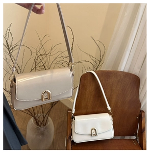 Détail de sacs à bandoulière en similicuir beige et blanc avec boucles dorées élégantes
