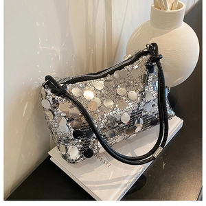 Macro detail of silver sequin texture on shoulder bag with black leather cord strap