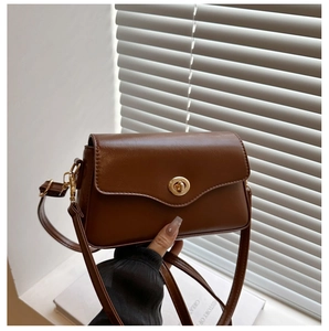 Détail du sac vintage caramel avec rabat ondulé et fermoir rotatif doré élégant