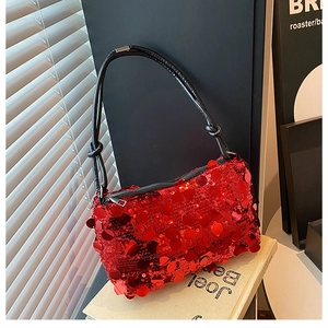 Detail of red sequin shoulder bag with black PU strap and decorative knot accents