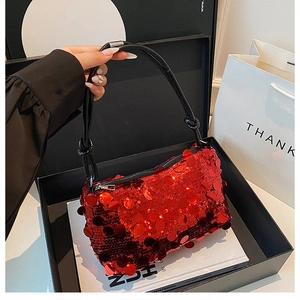 Detailed macro of red sequin shoulder bag featuring a black knotted leather strap