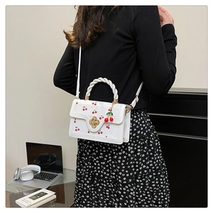 Detail of sweet cherry print bag showing woven handle and model carrying it