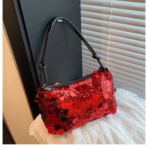 Detailed close-up of a stylish red sequined handbag with black shoulder strap and zipper