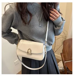 Détail d'un sac bandoulière élégant en similicuir crème avec boucle en métal doré