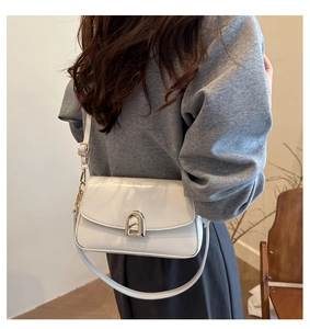 Vue latérale détaillée d'un sac à bandoulière blanc avec boucle métallique dorée