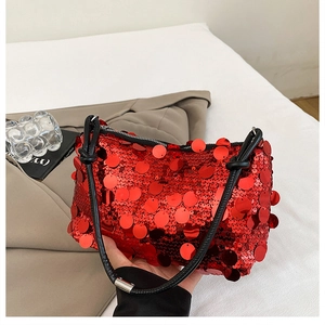 Macro view of red sequin shoulder bag showing overlapping round sequins and black handle