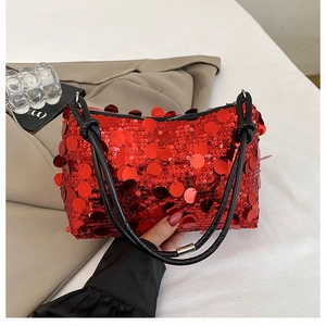 Detail of red oversized sequins on a stylish rectangular shoulder bag with black thin straps