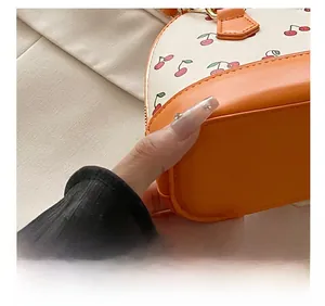 Close-up of precise stitching and cherry print on the bicolor shell handbag