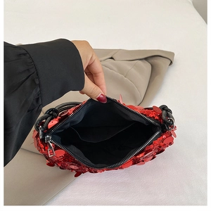 Detailed interior of red sequin handbag showing black fabric lining and functional inner pocket