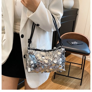 Close-up of a silver sequin shoulder bag with metallic mirror finish and knot strap