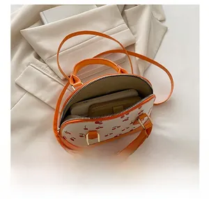 Interior view showing capacity of cherry print shoulder bag with metal zipper