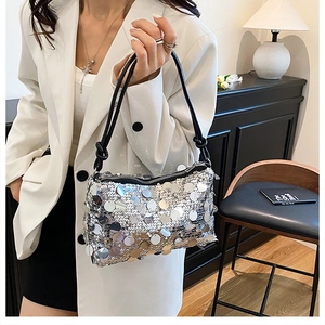 Close-up of silver sequin shoulder bag with black knotted strap and zipper detail