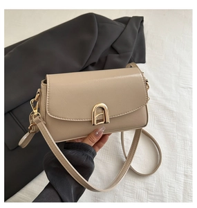 Détail du sac en similicuir beige avec fermoir en métal doré en U et bandoulière fine