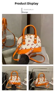 Detail of orange cherry print handbag with adjustable strap and smooth zipper closure