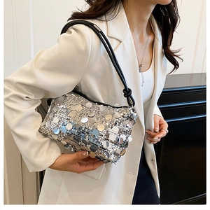 Close-up of silver sequin shoulder bag with black strap showing Y2K texture on model