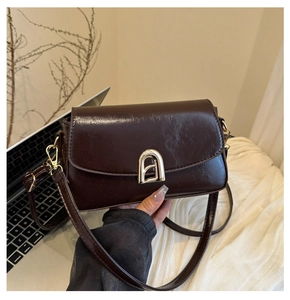 Vue détaillée du sac en similicuir marron à texture vintage et boucle dorée en fer