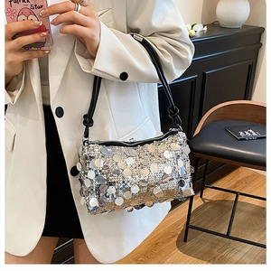 Detail of silver sequin shoulder bag with knot strap and reflective metallic texture