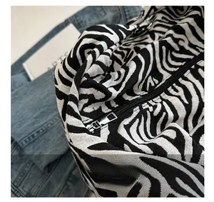 Détail du sac cabas en toile zébrée avec fermeture éclair argentée et texture du tissu