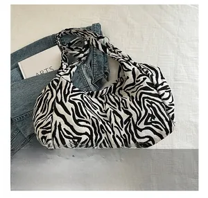 Détail d'un grand sac hobo imprimé zèbre avec bandoulière large dans un décor décontracté