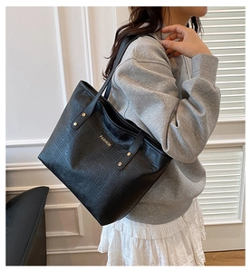 Détail du sac cabas noir avec similicuir gaufré géométrique et plaque de mode dorée