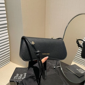 Minimalist black pebble leather shoulder bag with gold lettering and knotted strap