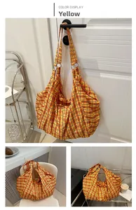 Détail du sac cabas à carreaux montrant l'anneau métallique et la texture de toile