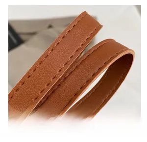 Détail de la poignée en cuir grainé marron avec coutures fines et artisanat renforcé
