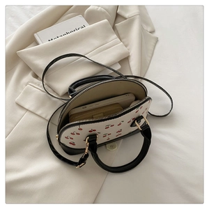 Interior view of cherry print bucket bag showing space for smartphone and long wallet