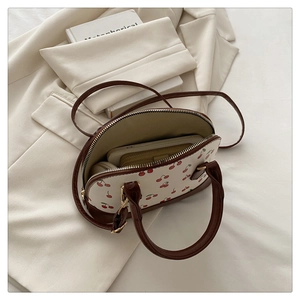 Detail of the cherry print bucket bag showing interior space for phone and wallet