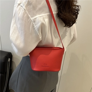 Chic red bucket shoulder bag with sleek textured leather and minimalist brand logo print