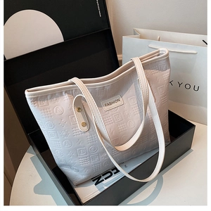 Gros plan du sac cabas blanc gaufré avec plaque Fashion dans un coffret cadeau noir élégant
