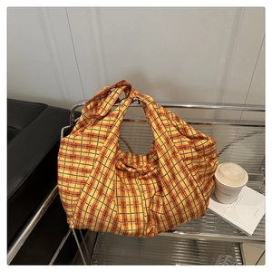 Détail du sac cabas à carreaux jaunes sur chariot en métal dans un décor de style