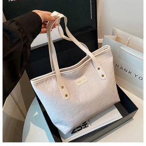 Détail du sac cabas blanc avec lettres embossées et plaque en métal doré FASHION