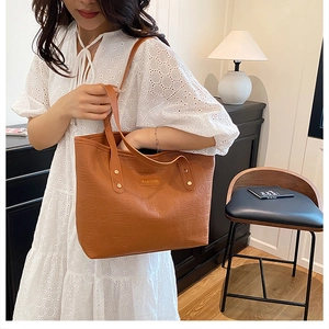 Détail d'un cabas en cuir marron avec gaufrage géométrique et plaque en métal Fashion