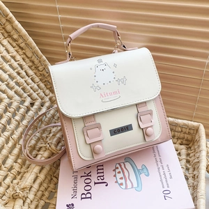 Pink and beige mini backpack with cartoon illustration on a rustic woven chair