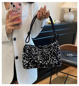 Detailed view of shimmering black sequin handbag with elegant knotted leather shoulder strap