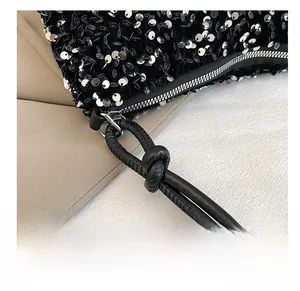 Detail showing shiny silver sequins on black fabric and silver metal zipper closure
