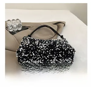 Close-up of black and white sequins texture on minimalist shoulder bag with slim strap
