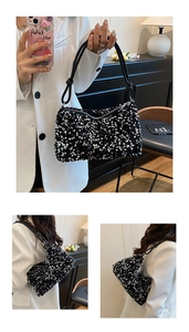 Macro shot of stylish black sequin handbag with knot detail shoulder strap and zipper closure