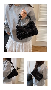 Close-up of black sequined shoulder bag with glossy finish and knotted leather strap