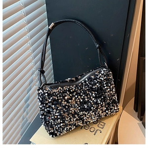 Detail of glittery sequin bag showing black leather strap with knot and zipper closure
