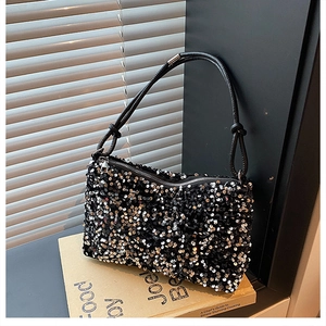 Detail of high-density black sequins on the baguette bag with leather strap and zipper