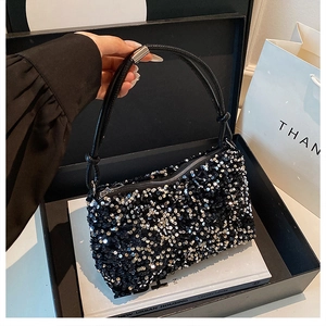 Detail of a black sequin evening bag featuring a double cord handle and silver hardware