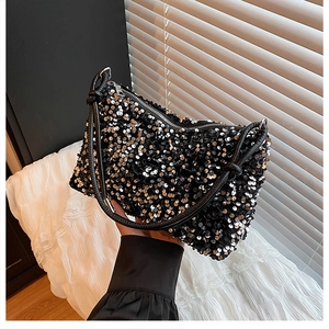 Close-up of sparkling black sequin shoulder bag with knot leather handle and zip closure