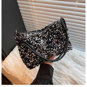 Close-up of sparkling sequin surface and black leather handles on a trendy handbag