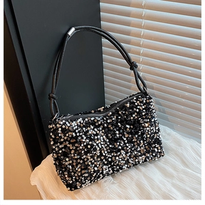 Close-up of sparkling black and silver sequins on a rectangular fashion handbag